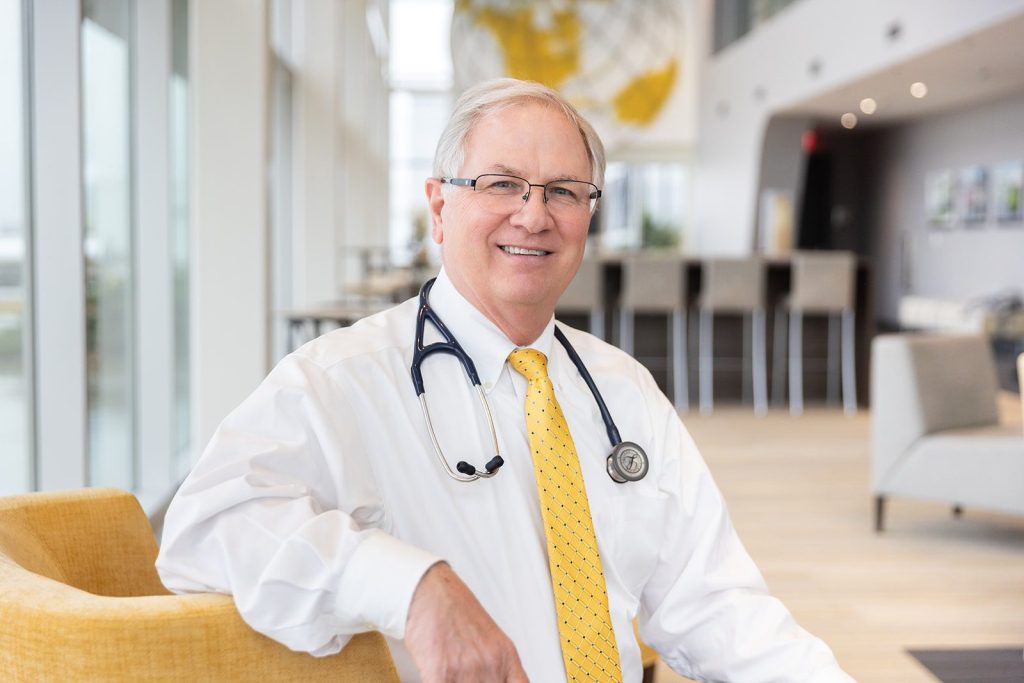 Doctor sitting in the bright, modern atrium of Amway's hangar at the airport, where his pilot medical exam office is located.